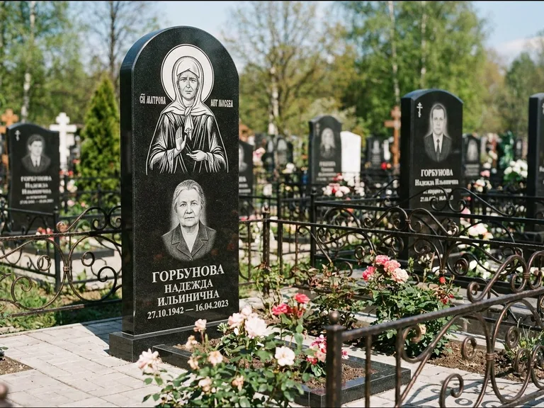 Памятник с гравировкой иконы: стела с арочным верхом и киотом под образ — гравировка образа Матроны Московской, гранитный цоколь с тёмной плиткой, работа «Ковалёв» в Липецке