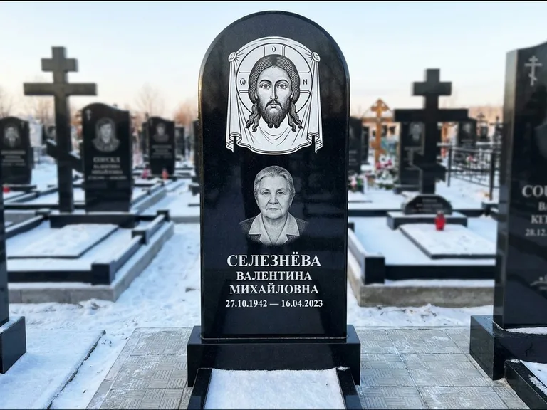 Памятник с гравировкой иконы: небольшая скромная одиночная стела с именной иконой — золочёный нимб на образе, аккуратный участок с газоном, работа «Ковалёв» в Липецке