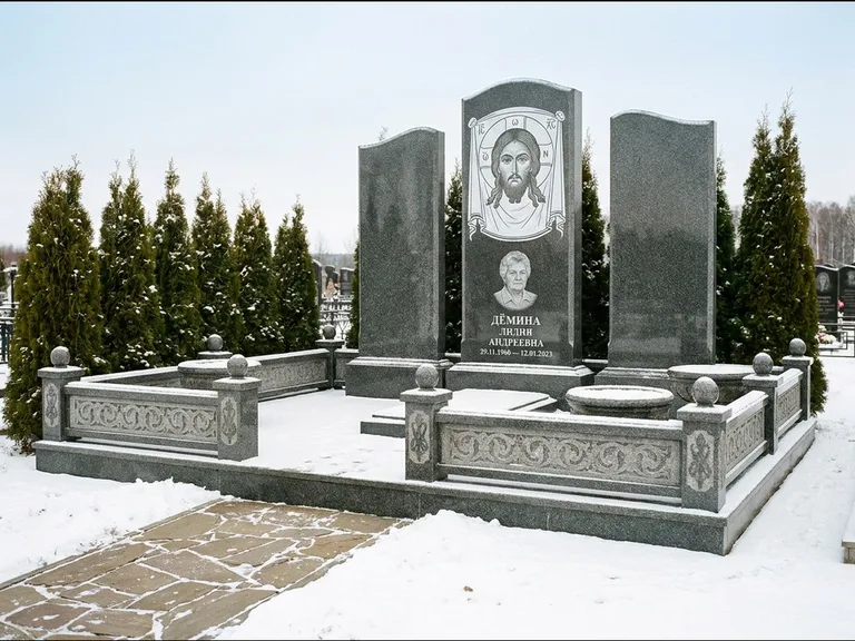 Памятник с гравировкой иконы: узкая вертикальная стела-пилон с ликом — икона в резной рамке-киоте, открытая лужайка без ограды, работа «Одинцов» в Липецке