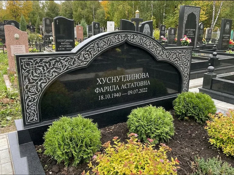 Мусульманский памятник: вытянутая горизонтальная семейная стела с аркой — белая гравировка силуэта мечети с минаретами, участок с декоративными кустами, работа «Зарипова» в Липецке