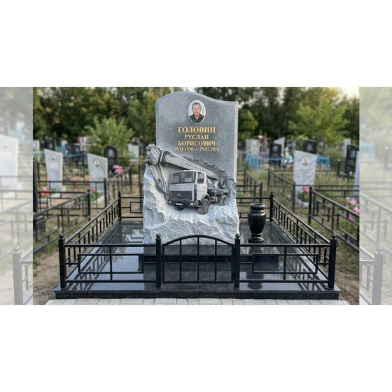 Гранитный памятник с барельефом автокрана и скальным краем